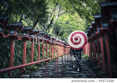 A woman with a Japanese umbrella walking around Kibune Shrine 44871886