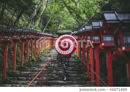A woman with a Japanese umbrella walking around Kibune Shrine 44871889