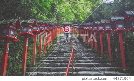 A woman with a Japanese umbrella walking around Kibune Shrine 44871904