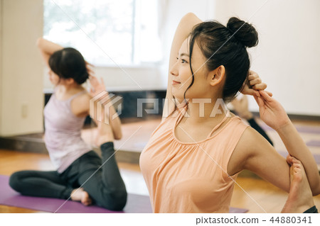 Young Japanese woman doing yoga pose of pigeon Young Japanese woman doing yoga pose of pigeon 44880341