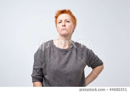 woman with short red hair on a gray background. 44880351