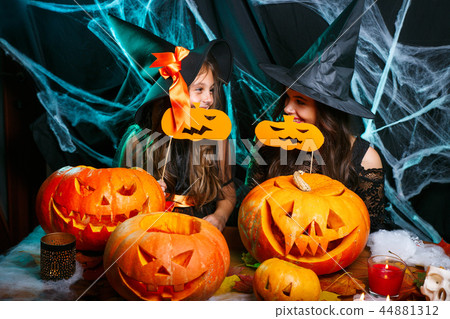 Happy Halloween. Mother and her daughter in witch costumes having fun at home. Happy Halloween. Mother and her daughter in witch costumes having fun at home. 44881312