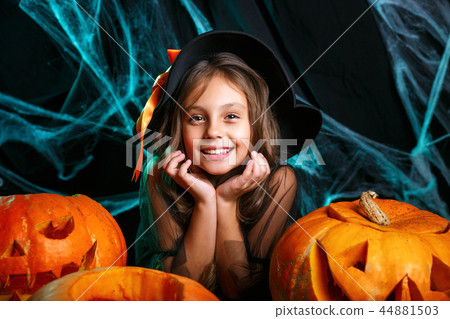 Happy halloween. Pretty little child girl in witch costume with carving pumpkin . Happy family 44881503