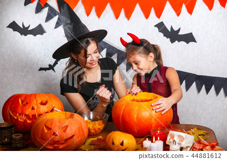 Happy Halloween. Family mother and child daughter are preparing for Halloween and decorate the house 44881612