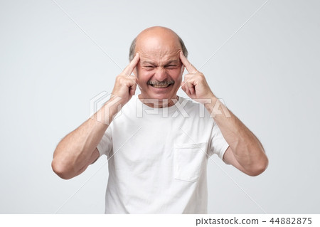 man holds fingers on temples, has bad memory man holds fingers on temples, has bad memory 44882875