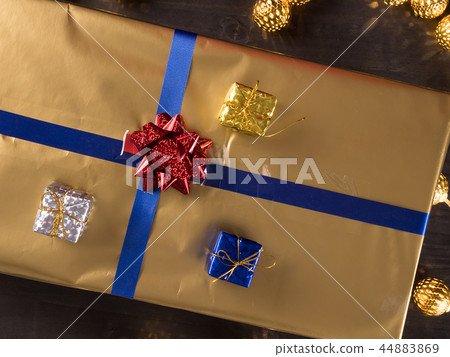 Top view of golden christmas gift boxes on old vintage wooden background Top view of golden christmas gift boxes on old vintage wooden background 44883869