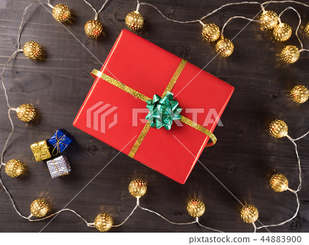 Christmas gift box on wooden background with small presents and Christmas light. 44883900
