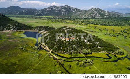 Aerial view of the landscape of Lake Skadar in the mountain and the island with monastery on a Aerial view of the landscape of Lake Skadar in the mountain and the island with monastery on a 44883905