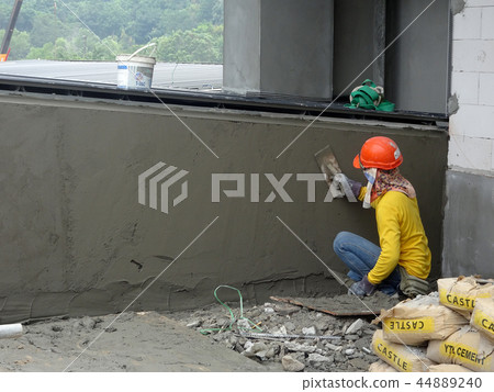 Brick wall plastered by construction workers 44889240