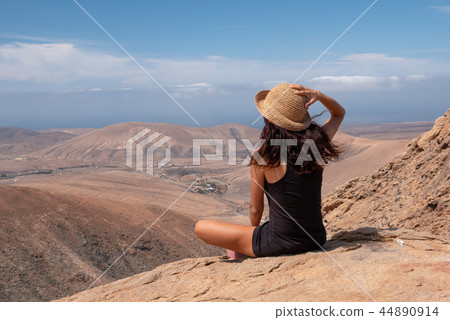 relaxed girl looking at a landscape from the top of a mountain 44890914