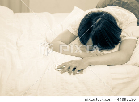 一個睡在床上的年輕女人 44892150