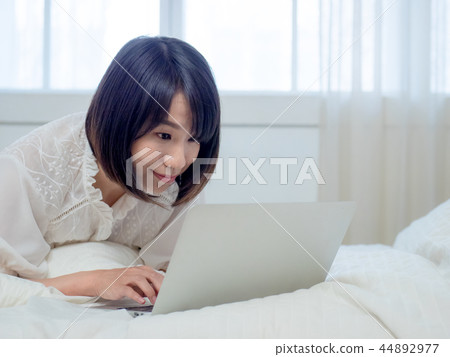 婦女在床上的操作一台計算機 婦女在床上的操作一台計算機 44892977