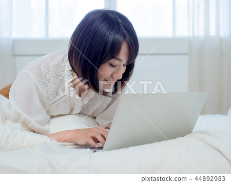 婦女在床上的操作一台計算機 婦女在床上的操作一台計算機 44892983