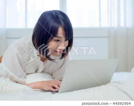 婦女在床上的操作一台計算機 婦女在床上的操作一台計算機 44892984