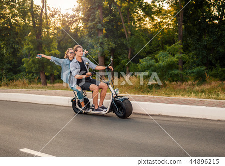 Lovely young couple driving electric bike during summer 44896215