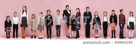 Cute stylish children on pink studio background. The beautiful teen girls and boy standing together Cute stylish children on pink studio background. The beautiful teen girls and boy standing together 44904195