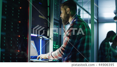 Bearded IT specialist setting servers in data center Bearded IT specialist setting servers in data center 44906395