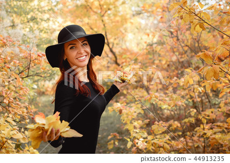woman in dress and hat on background of autumn foliage woman in dress and hat on background of autumn foliage 44913235