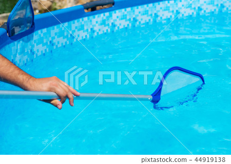 Backyard garden swimming pool cleaning close up Backyard garden swimming pool cleaning close up 44919138