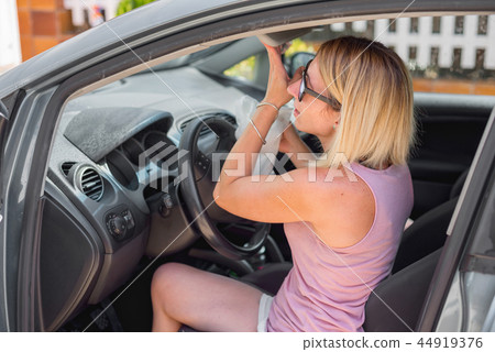 Young woman cleaning car interior Young woman cleaning car interior 44919376
