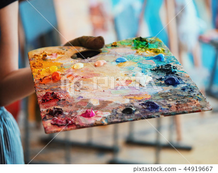 Wooden art palette with oil paints. Mixing colors together. Artistic instrument with many colors 44919667