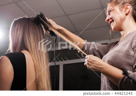 hairdresser making a gauffer hairdo of a girl hairdresser making a gauffer hairdo of a girl 44921245
