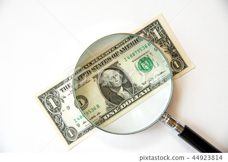 一美元的鈔票和一個放大鏡 44923814