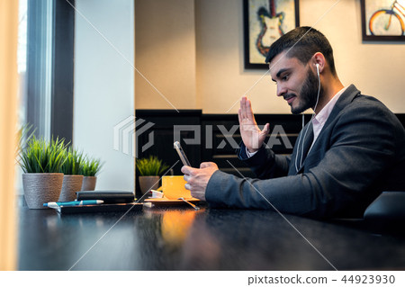 Businessman is talking on video using a smartphone Businessman is talking on video using a smartphone 44923930
