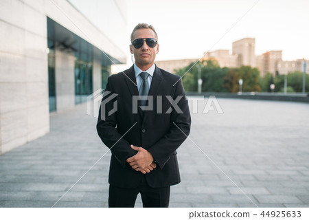 Male bodyguard in suit, earpiece and sunglasses 44925633