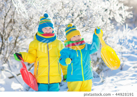 Kids play in snow. Winter sled ride for children Kids play in snow. Winter sled ride for children 44928191