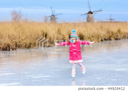 Child ice skating on frozen mill canal in Holland. Child ice skating on frozen mill canal in Holland. 44928412