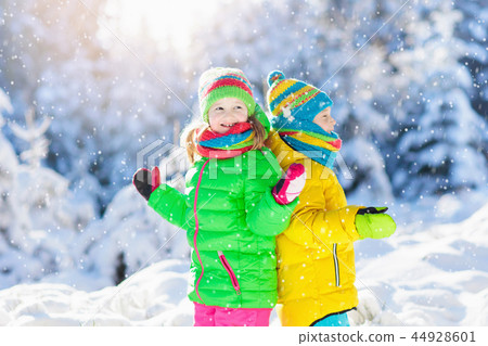 Child playing with snow in winter. Kids outdoors. 44928601