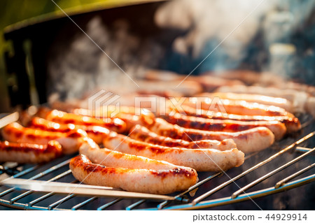 BBQ with fiery sausages on the grill BBQ with fiery sausages on the grill 44929914