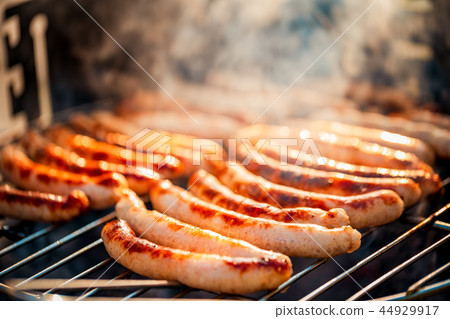 BBQ with fiery sausages on the grill 44929917