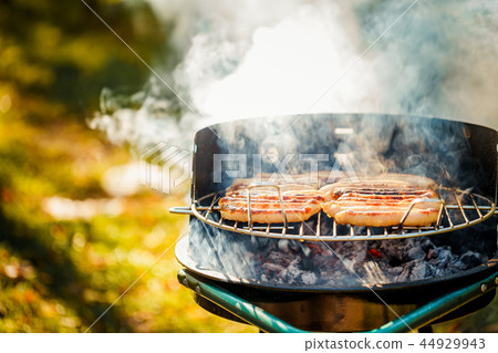 BBQ with fiery sausages on the grill BBQ with fiery sausages on the grill 44929943