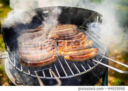BBQ with fiery sausages on the grill BBQ with fiery sausages on the grill 44929998