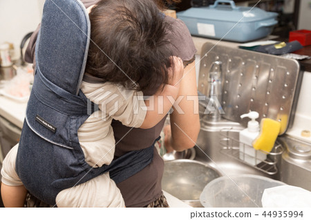 Senior doing housework while taking a baby (focus on the baby) 44935994