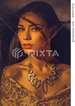 beautiful young woman with necklace in golden light beautiful young woman with necklace in golden light 44937979