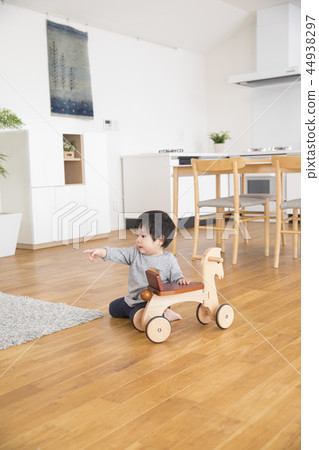 Boy playing with a wooden horse Boy playing with a wooden horse 44938297