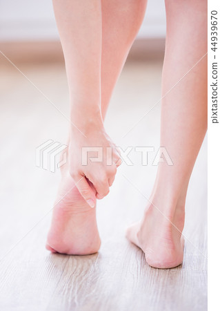 Woman applying cream onto foot Woman applying cream onto foot 44939670