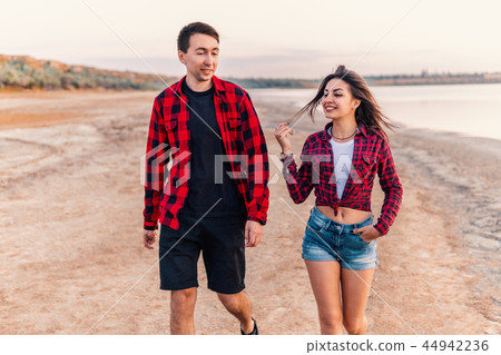 oung couple on the beach walking together oung couple on the beach walking together 44942236