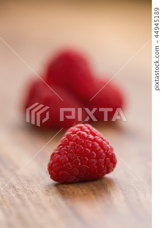 Ripe raspberries on wood background Ripe raspberries on wood background 44945189