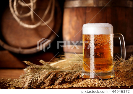 Mug of beer .With wheat and barley and barrels  44946372