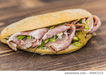 Delicious sandwich with meat and fresh vegetables Delicious sandwich with meat and fresh vegetables 44947215