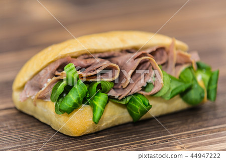 Delicious sandwich with meat and fresh vegetables Delicious sandwich with meat and fresh vegetables 44947222