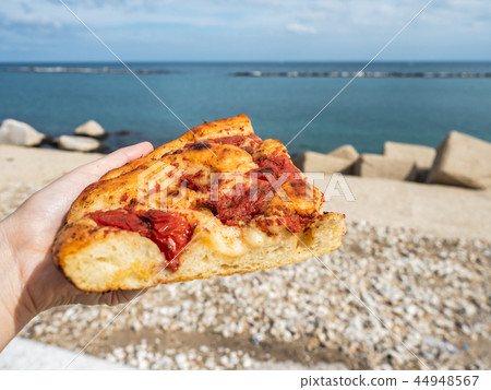 Piece of fresh, fragrant, ruddy Neapolitan pizza Piece of fresh, fragrant, ruddy Neapolitan pizza 44948567