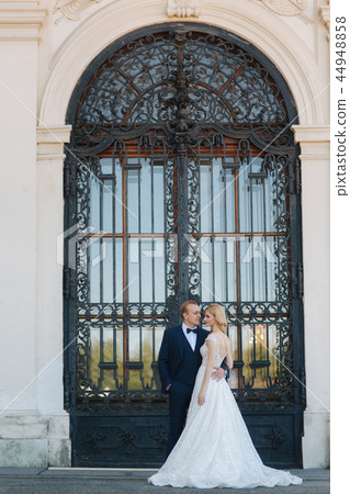 Groom and bride neat the big door of great palace 44948858