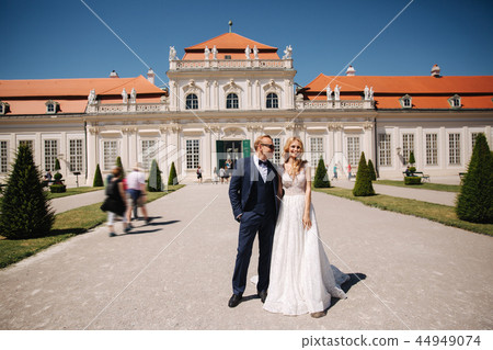 Beautiful young bride with her handsome groom walking in palace Belvedere 44949074