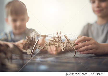 Close up of creative children making wooden figures together 44949755