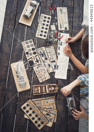 Top view of the table covered of pieces of wooden constructor Top view of the table covered of pieces of wooden constructor 44949815